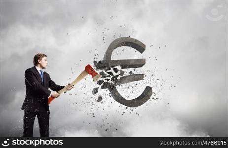 Currency concept. Young businessman breaking dollar stone sign with axe
