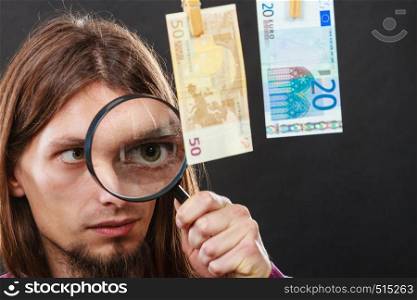 Currency exchange concept. Man worker check verify money cash. Payment hang on laundry line. Guy with loupe.. Man verify money cash