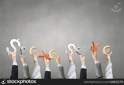 Currency symbols in hands. Group of business people holding money currency signs