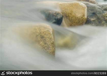 Current between the stones of the river, blurred by a slow shutter speed
