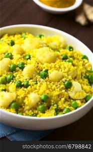 Curried couscous with peas, cauliflower, ginger and garlic, photographed with natural light (Selective Focus, Focus in the middle of the dish)