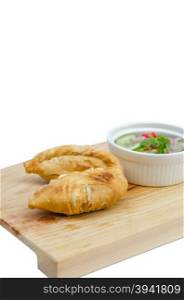 Curry puff pastry with sweet sauce on wooden plate over white background. Curry puff pastry