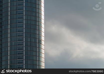 Curved Glass Office Building with Grey Clouds