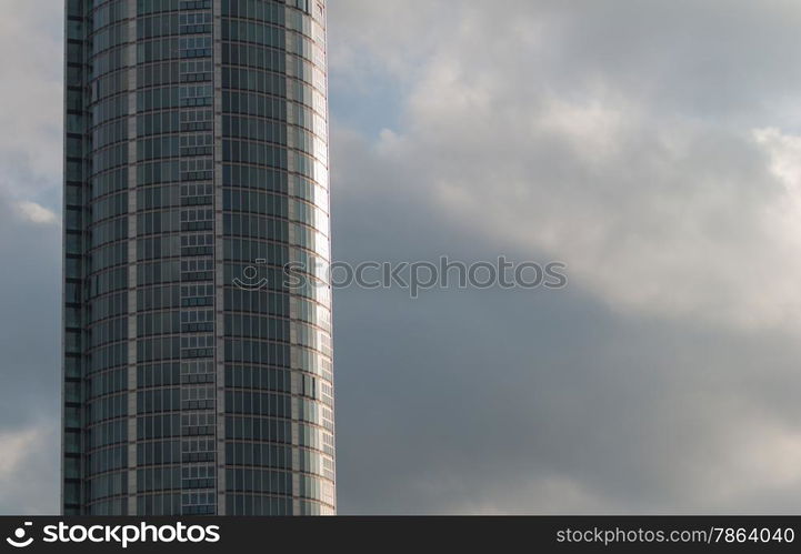 Curved Glass Office Building with Grey Clouds