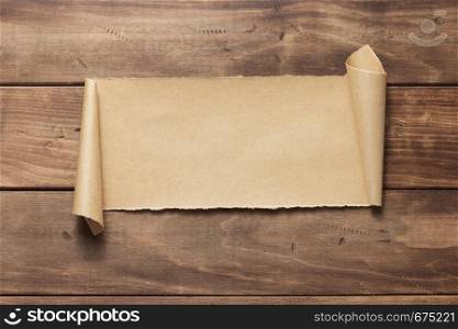 curved or scrolled paper on wooden background texture
