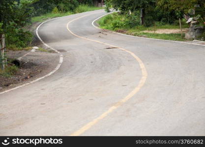 Curved road is curved, not much. The side of the road with a tree.