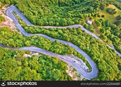 Curvy road serpentines in green Alpine ladscape aerial view, Agueglio Pass mountain road above Varenna, Como lake, Italy