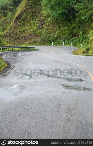 Curvy road. The road is crooked, turn on the hill. Near cliffs. The ascent to the summit of mountain