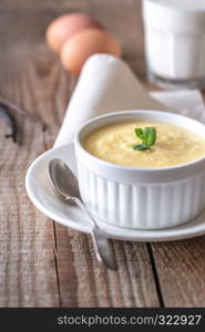 Custard decorated with mint and vanilla pods on the wooden background