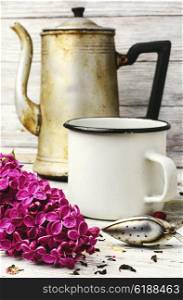 Custard flavored tea,spoon for welding and branch of blossoming lilac