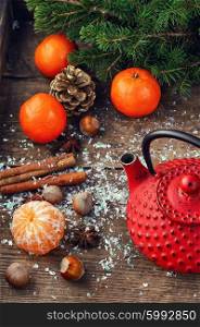 Custard red tea,tangerines,hazelnuts and cinnamon amid the branches of Christmas tree