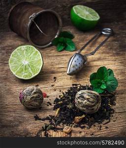 custard with spoon and spilled tea brewing and raspberry leaves on wooden background in country style.Selective focus. tea brew with lime and mint on wooden background