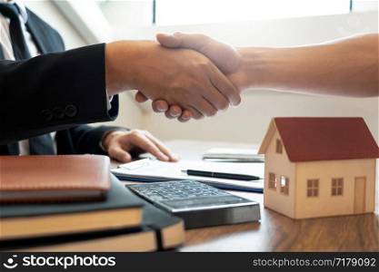 Customer and broker shake hands agreeing to buy new house at meeting after making sale purchase deal or finish buying or rental real estate with agent, Success deals concept.
