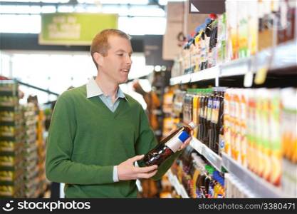 Customer buying bottle of juice in the supermarket