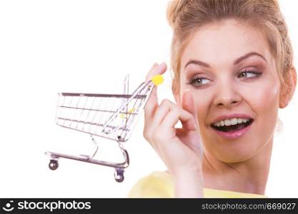 Customer buying in shop. Happy woman holding small tiny shopping cart trolley about to buy products.. Woman holding shopping cart