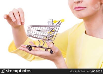 Customer buying in shop. Woman holding small tiny shopping cart trolley about to buy products.. Woman holding shopping cart