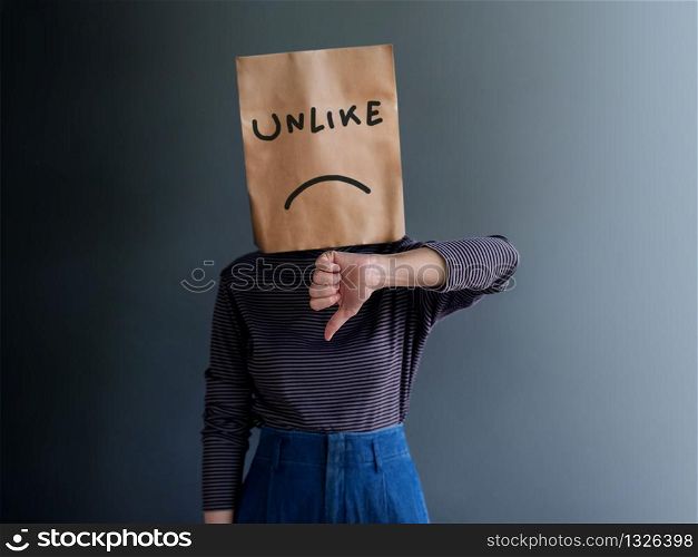 Customer Experience or Human Emotional Concept. Woman Covered her Face by Paper Bag. present Disappointed Feeling by Thumb Down Gesture Sign and Unlike Text