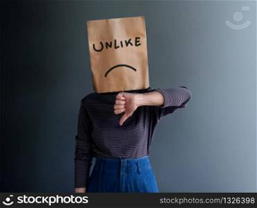 Customer Experience or Human Emotional Concept. Woman Covered her Face by Paper Bag. present Disappointed Feeling by Thumb Down Gesture Sign and Unlike Text