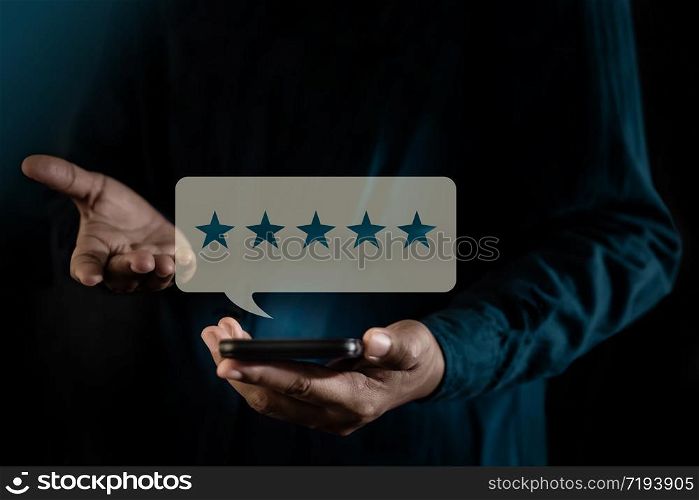 Customer Experiences Concept. a Modern Man presenting Five Star Rating for Positive Review via Smartphone. Client&rsquo;s Satisfaction Surveys on Mobile Phone. Front View