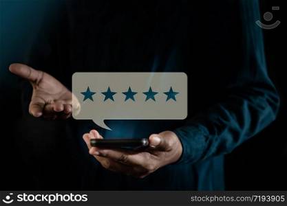 Customer Experiences Concept. a Modern Man presenting Five Star Rating for Positive Review via Smartphone. Client&rsquo;s Satisfaction Surveys on Mobile Phone. Front View