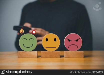 Customer feedback results in hand-picked smiley face on a wooden block circle, signifying the best service and satisfaction. 5-star rating concept.. Selecting a smiley face on a wooden block circle