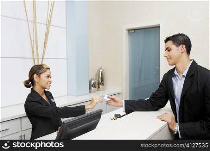 Customer giving a credit card to a female receptionist
