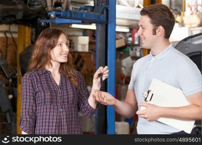 Customer Giving Car Keys To Garage Mechanic