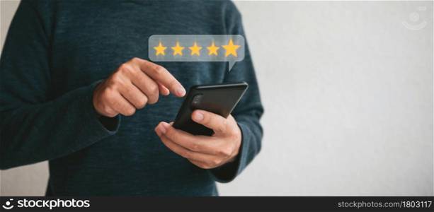 Customer hand holding smart phone and five star with copy space. Best Excellent Services Rating for Satisfaction.Customer experience satisfaction concept.
