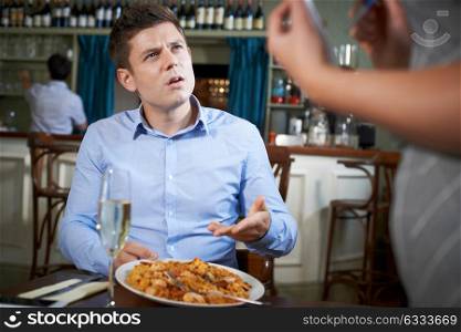 Customer In Restaurant Complaining To Waitress About Food