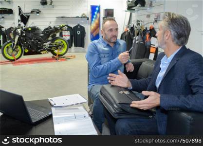 customer listening to motorcycle salon manager