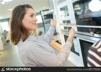 customer looking at built-in ovens in domestic appliances shop