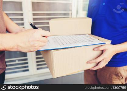 Customer Man signature in clipboard to receive package from professional delivery man at home