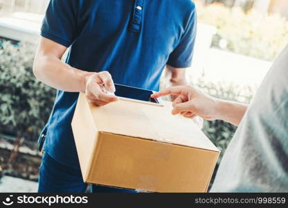 Customer Man signature in Smart Phone to receive package from professional delivery man at home