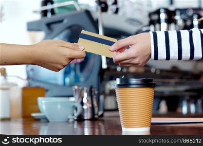 Customer paying coffee by credit, debit electronic card at cafe counter, food and drink business concept
