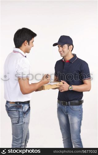 Customer receiving package from delivery man against white background