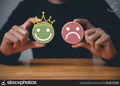 Customer satisfaction survey concept, a man’s hand selecting a smiley face on a wooden block circle to indicate excellent service and experience.