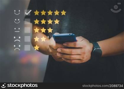 Customer Satisfaction Survey Concept Users rate the service experience on the online application. Customers can assess the quality of service.Hand holding smart phone.