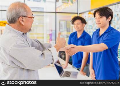Customer satisfied to sales staff service finish deal good price and shake hands together.