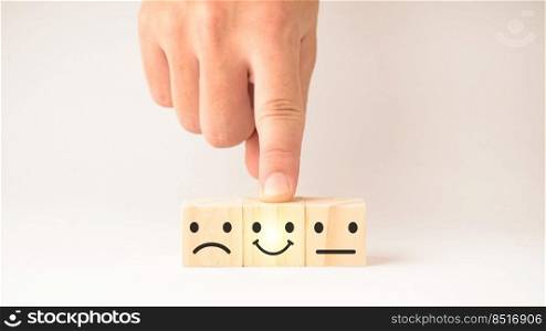 Customer service and Satisfaction concept ,Business people show a feedback with smile face wood cube happy Smiley face icon to give satisfaction in service. rating very impressed.
