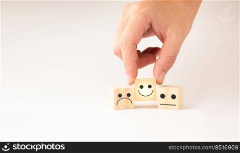 Customer service and Satisfaction concept ,Business people show a feedback with smile face wood cube happy Smiley face icon to give satisfaction in service. rating very impressed.