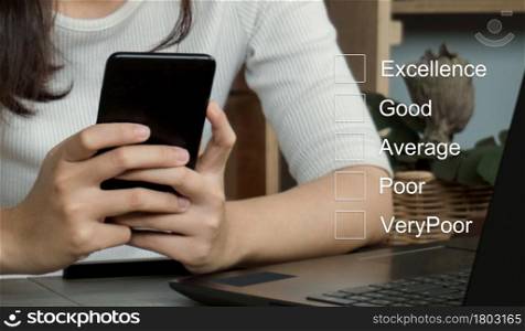 Customer service evaluation concept.Businesswomen hand putting check mark a checkbox on smarthphone for a satisfaction survey.