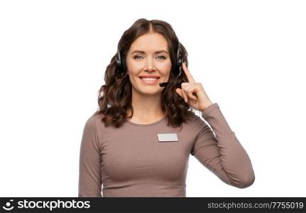 customer service, sale and business concept - happy female helpline operator or shop assistant with headset and name tag over white background. female helpline operator with headset and name tag