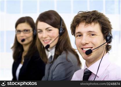 Customer service team working in headsets, smiling.