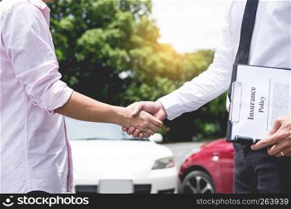Customer shake hand with auto insurance agents examining car crash owner after agreeing find a friendly agreement after a car accident to terms of insurance On the road.