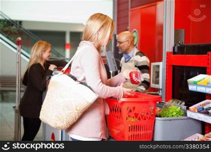 Customer shopping in supermarket with people in the background