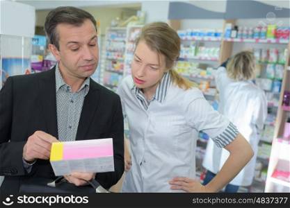 customer showing prescription to pharmacist