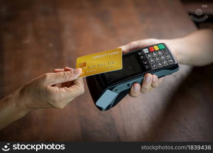 Customer using credit card for payment to owner at cafe,Payment transaction with card.