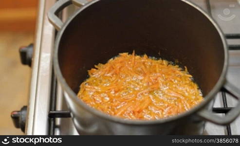 cut carrots are roasted in pan.