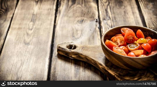Cut fresh tomatoes in a wooden bowl. On wooden background.. Cut fresh tomatoes in a wooden bowl.