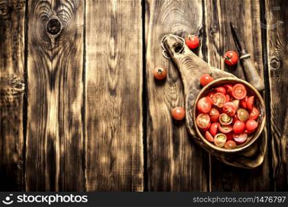 Cut fresh tomatoes in a wooden bowl. On wooden background.. Cut fresh tomatoes in a wooden bowl.